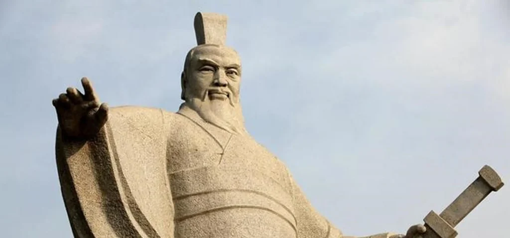 Statue of Wu Wang, an ancient leader, adorned with a crown and traditional attire, gripping a sword in his right hand.