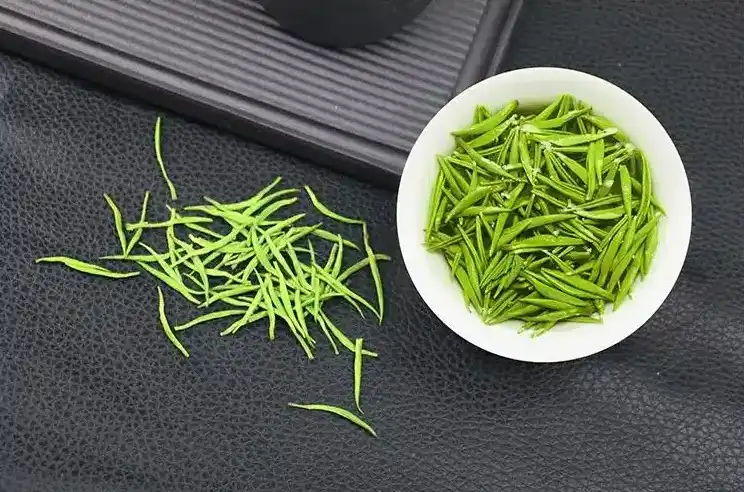 Fresh Meitan Cuiya unfermented Chinese green tea leaves with vibrant emerald color, showcasing traditional kill-green process that preserves natural polyphenols and amino acids in TeaChuck's premium tea products